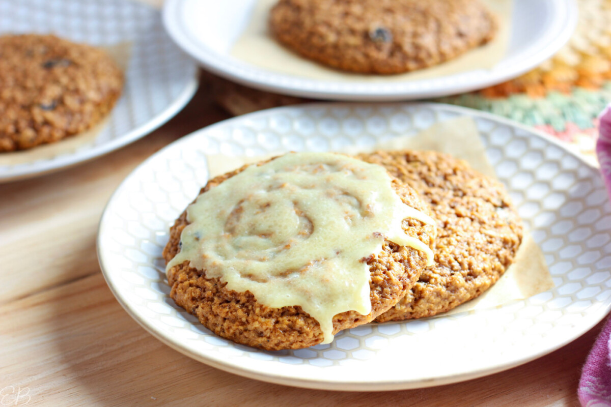 up close photo of two healthy banana oatmeal cookies on plate with cocoa butter glaze on one