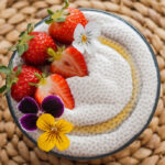 overhead view of strawberries and maple syrup, plus flowers, on simple 2 ingredient chia pudding