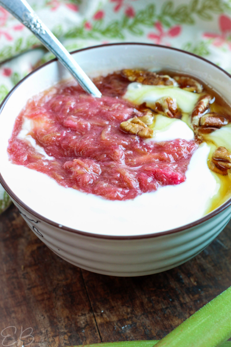 side angle of rhubarb sauce on yogurt with pure maple syrup and pecans