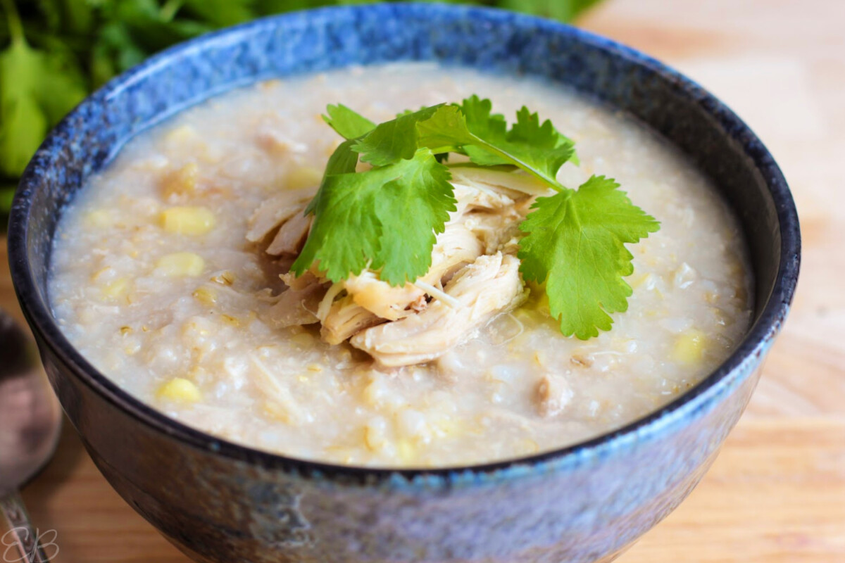 up close photo of healthiest congee in bowl topped with chicken and cilantro