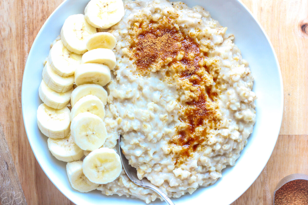 overhead view of no-stir oatmeal in bowl with sliced banana and coconut sugar sprinkled over the top