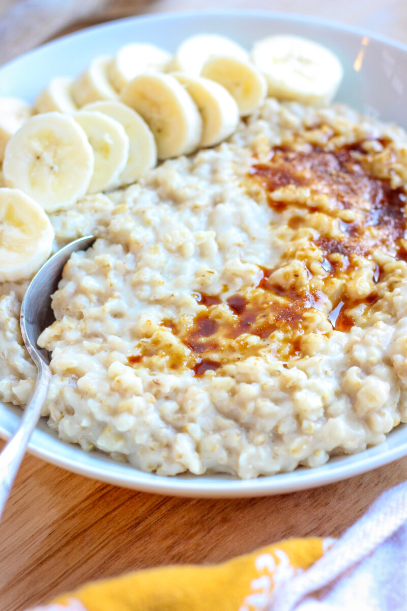 side angle view of no-stir oatmeal in bowl with sliced banana and coconut sugar sprinkled over the top