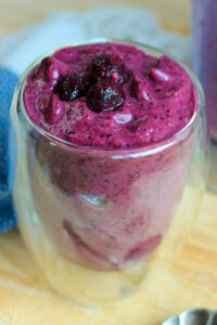 side angle view of best textured healthy blueberry smoothie in glass