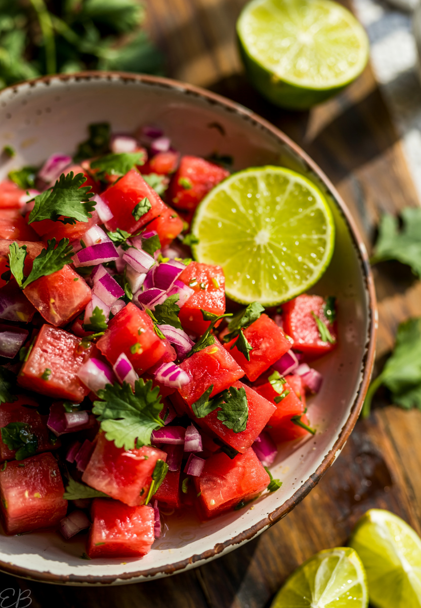overhead view of watermelon pico de gallo in serving bowl with lime