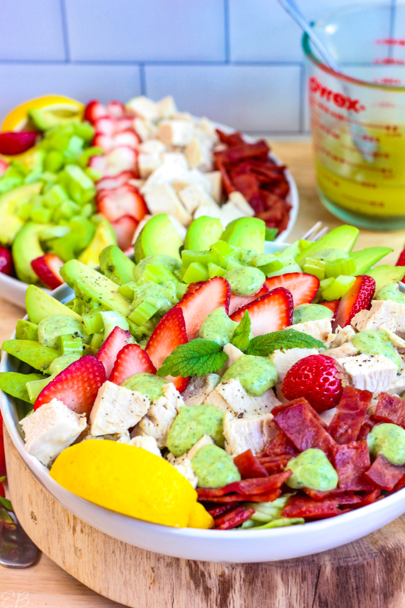 side angle view of Strawberry Cobb Salad composed on white plate with second plate in background