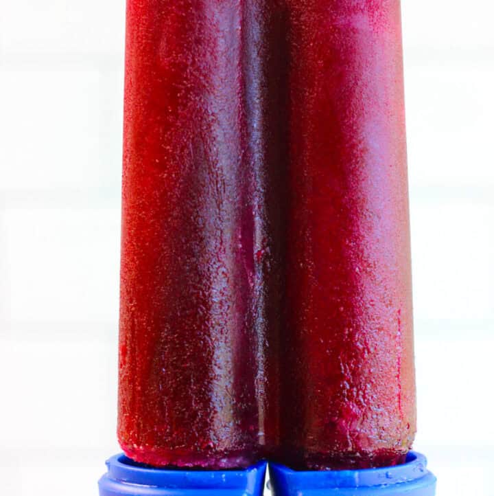 holding up a concord grape juice popsicle