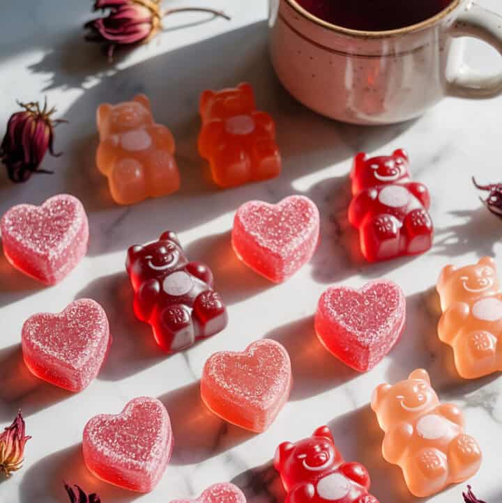 herbal tea gummies lined up on a marble surface, in flavors of hibiscus and rose