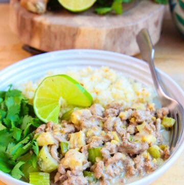 ground turkey curry on white plate with cauliflower rice and fresh cilantro