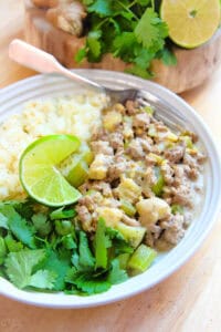 ground turkey curry on white plate with cauliflower rice and fresh cilantro