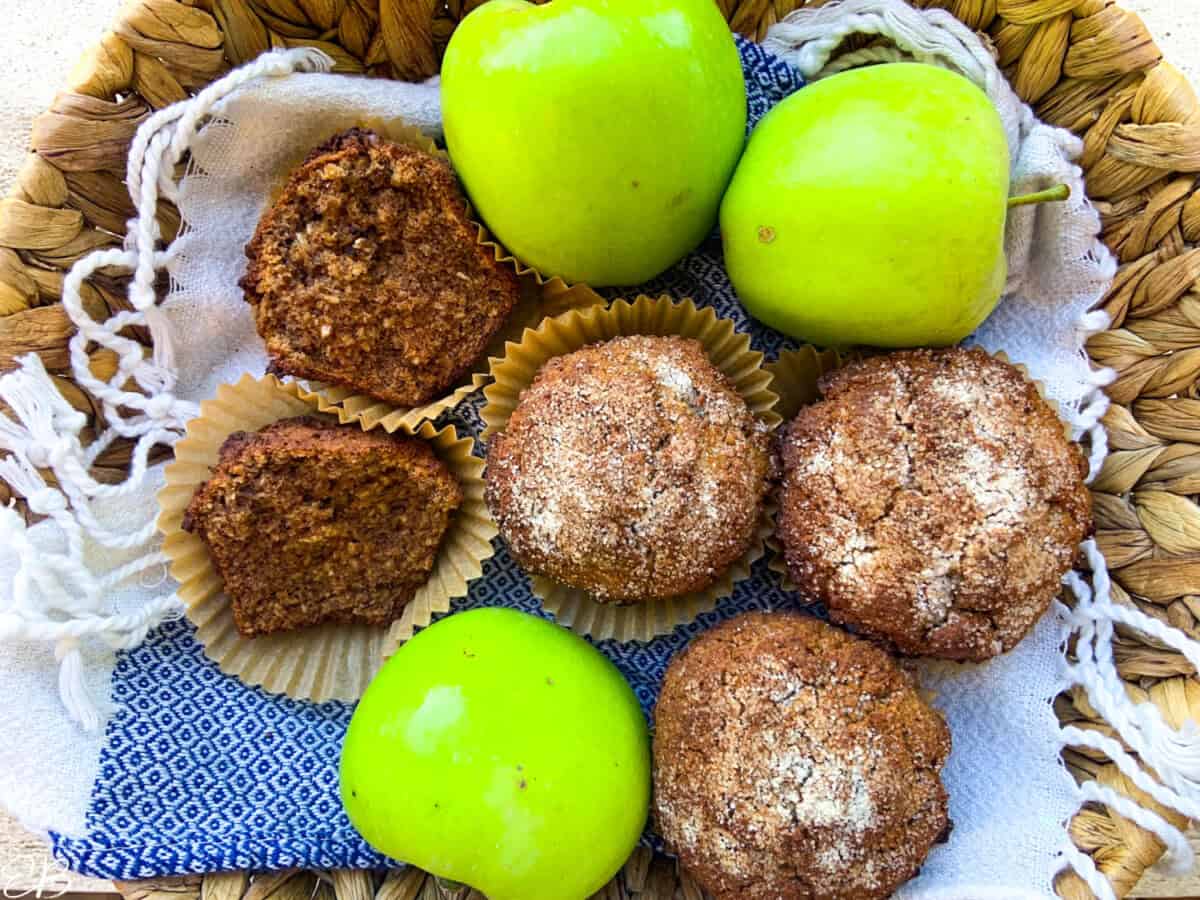 a basket full of muffins and apples