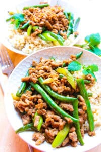 up close thai ground turkey and green beans served with brown rice in bowls
