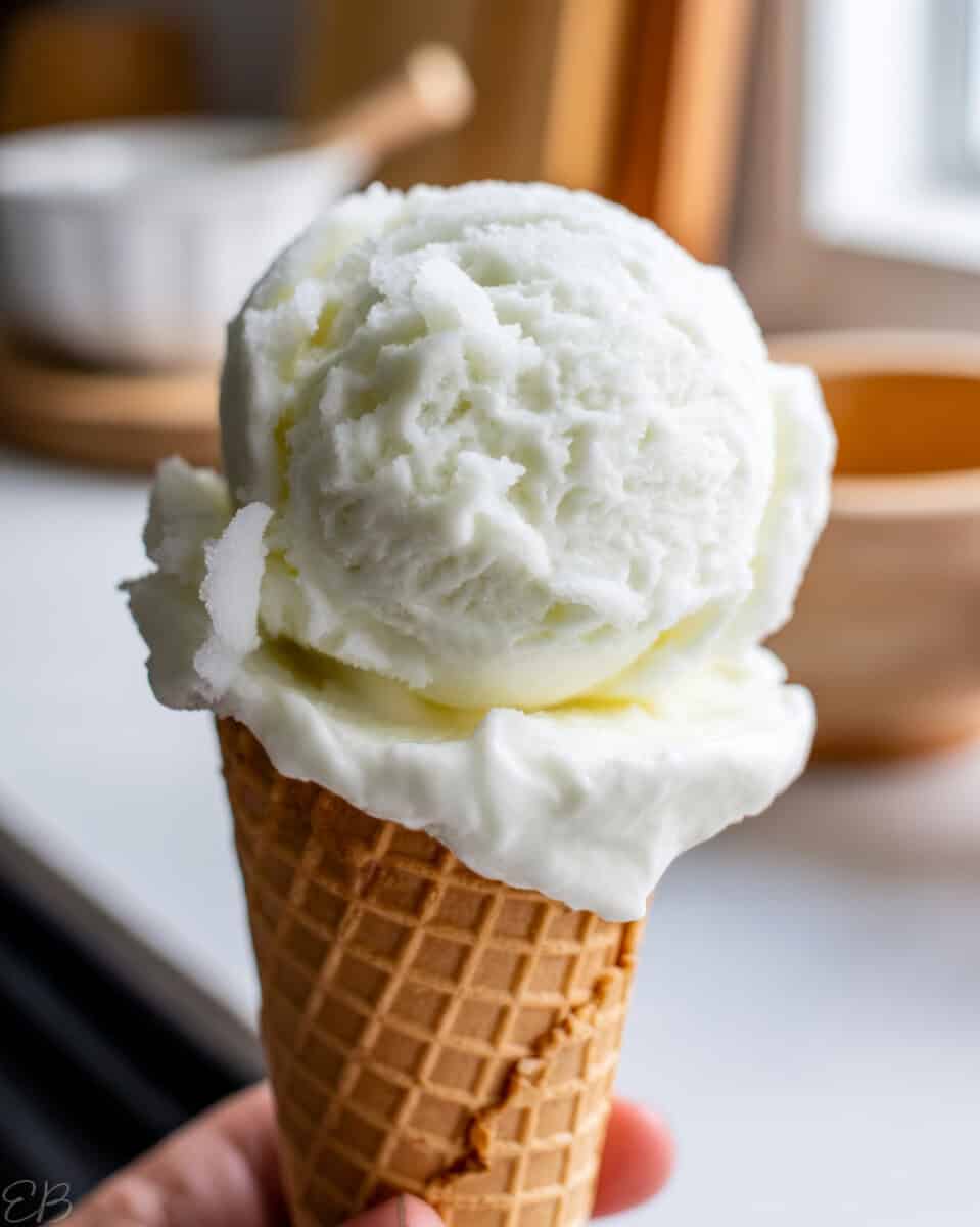 holding a cone of peppermint sherbet in the kitchen