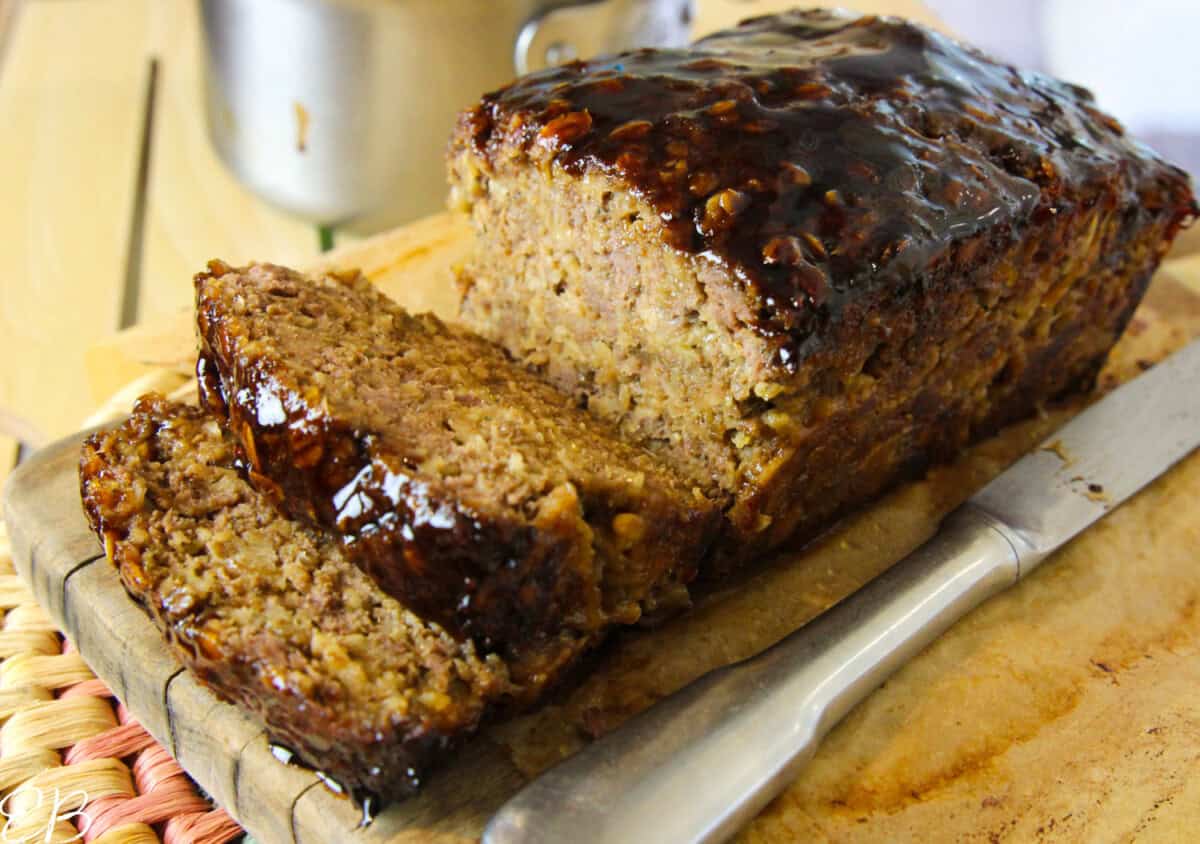 landscape photo of healthy meatloaf with oatmeal, sliced to serve with shiny glaze