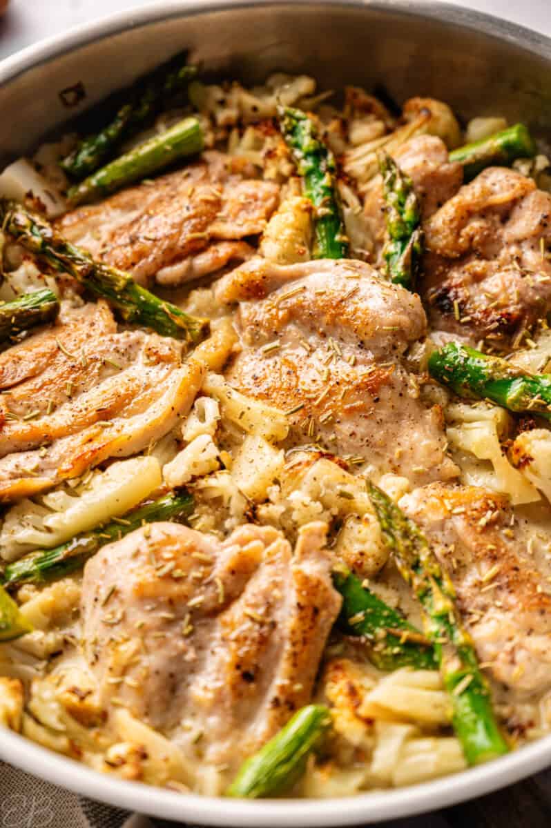 serving a chicken thigh from the pan of marry me chicken