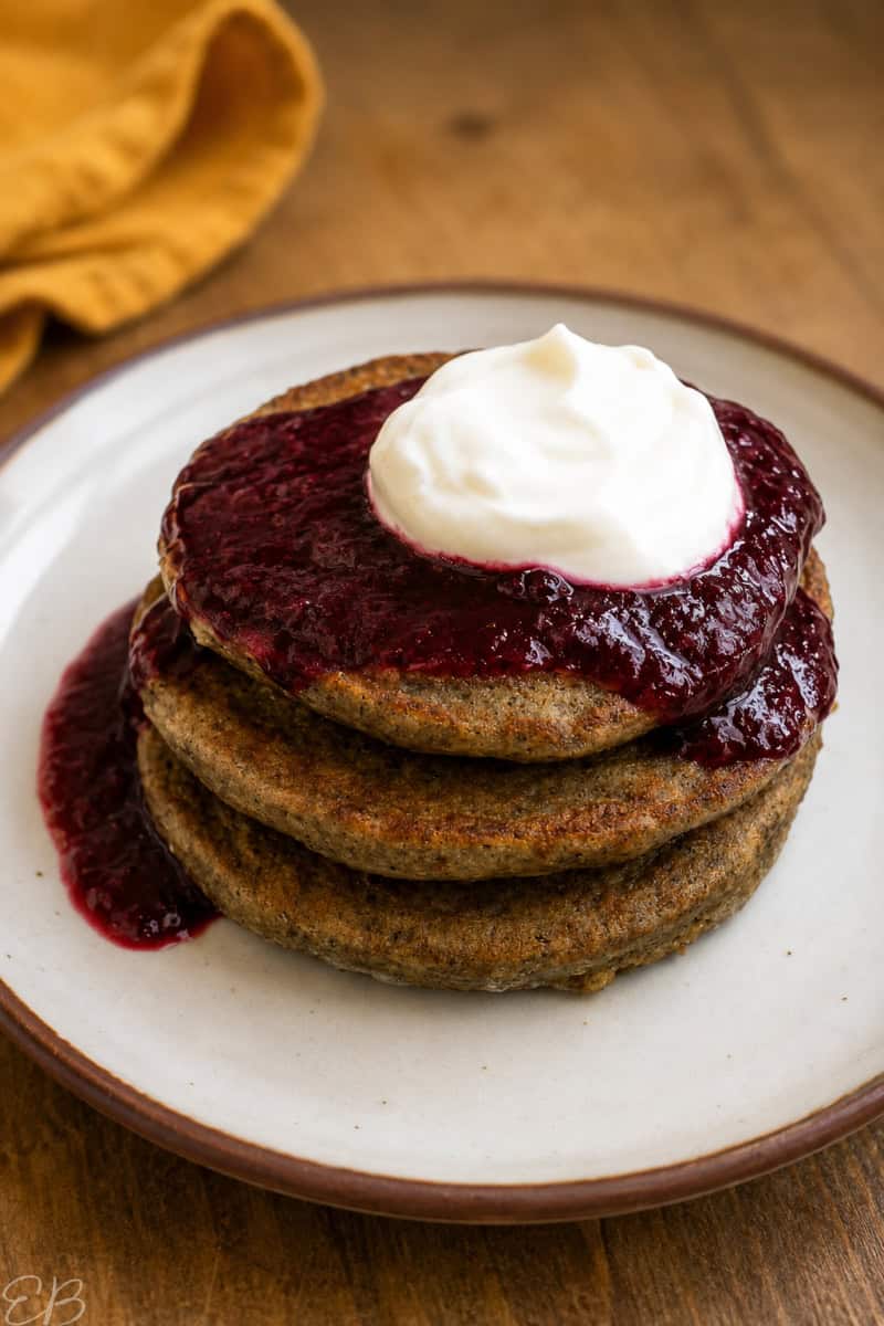 cricket flour pancakes stacked with berry sauce and coconut yogurt