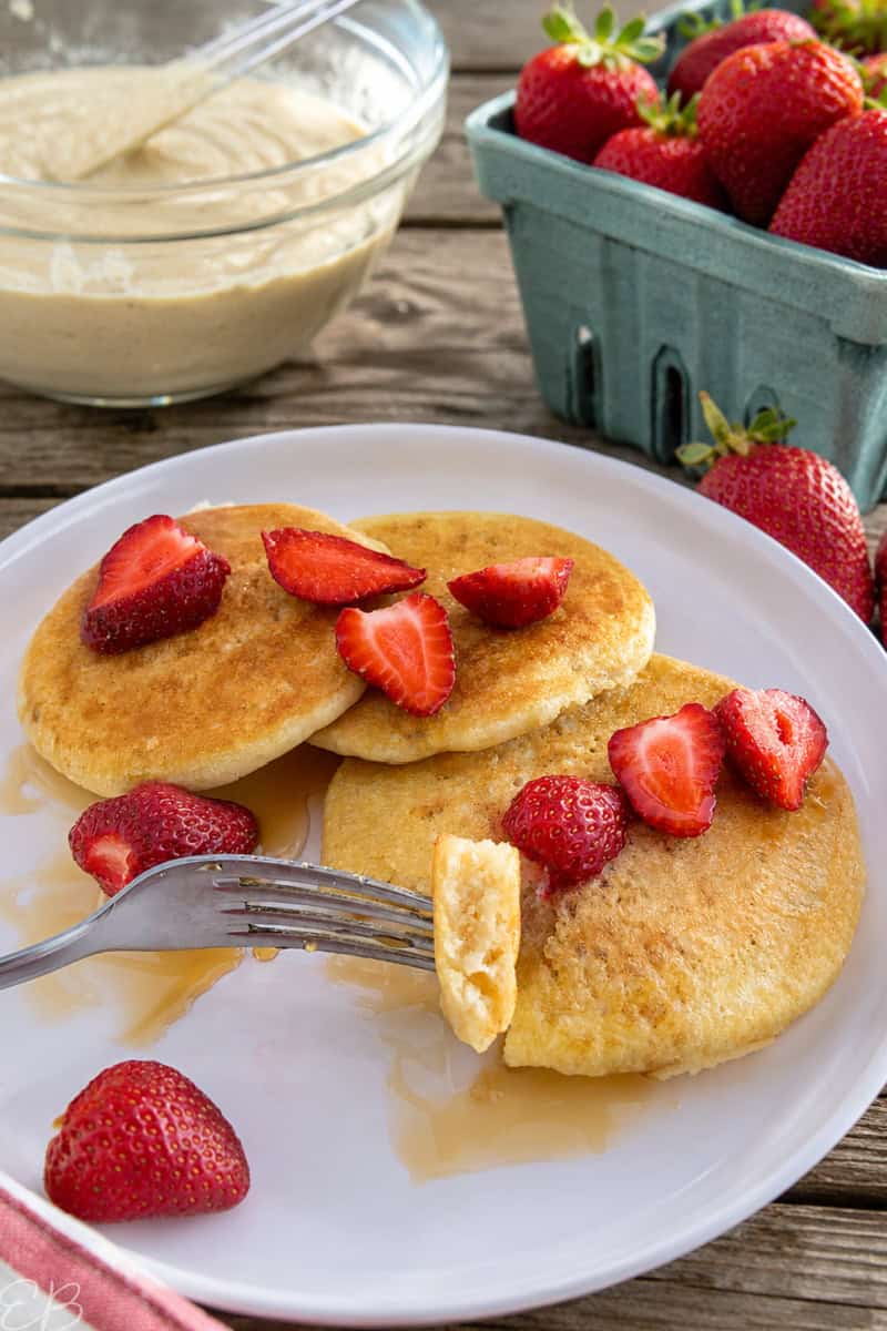 sourdough pancakes served on white plate with strawberries