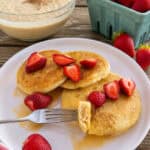 sourdough pancakes served with fresh strawberries on white plate