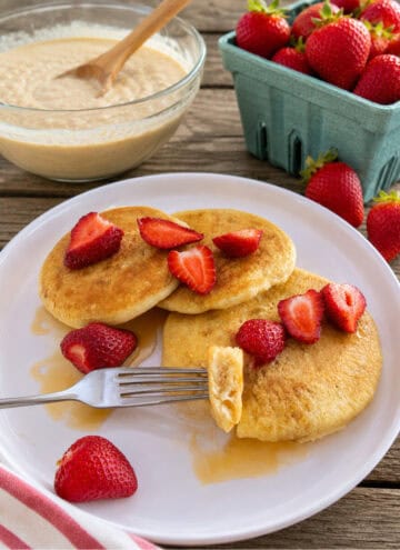 sourdough pancakes served with fresh strawberries on white plate