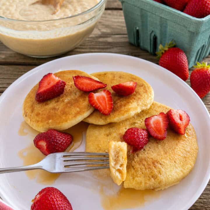 sourdough pancakes served with fresh strawberries on white plate