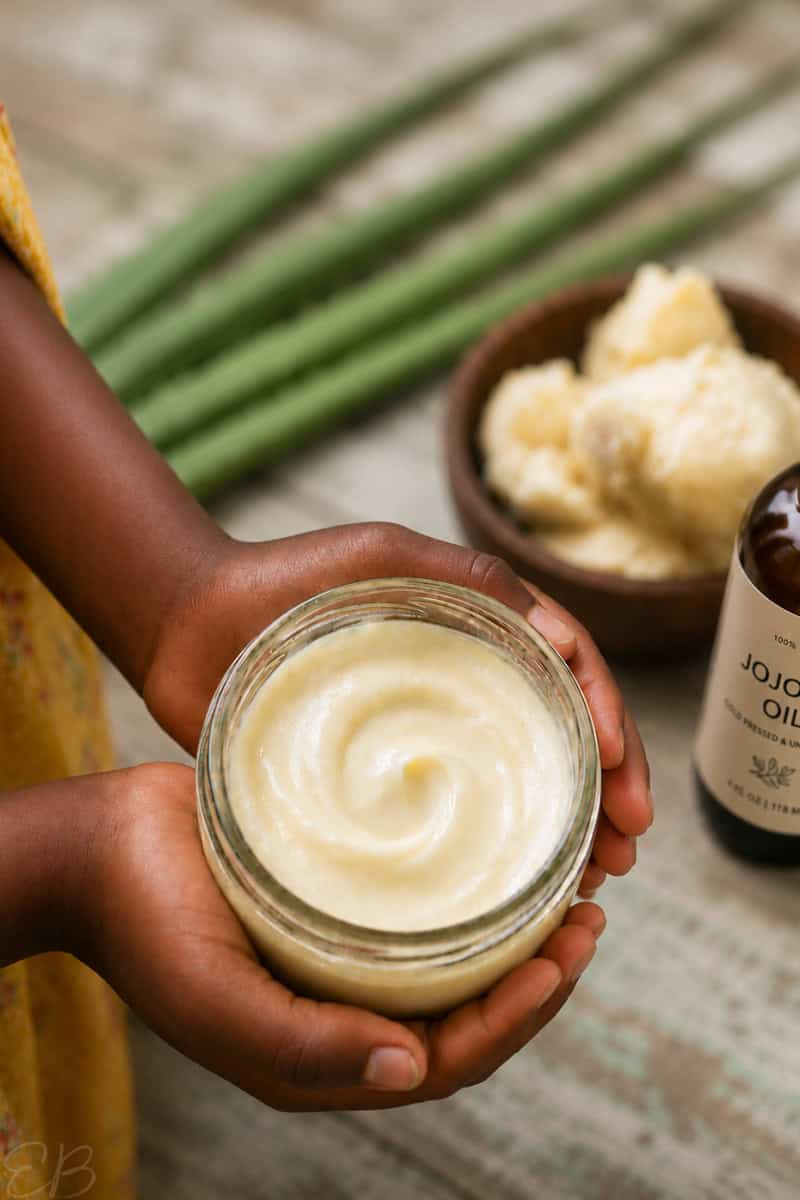 3-Ingredient DIY Hair Detangler for 4C Hair in jar held by girl's hands with ingredients in the background