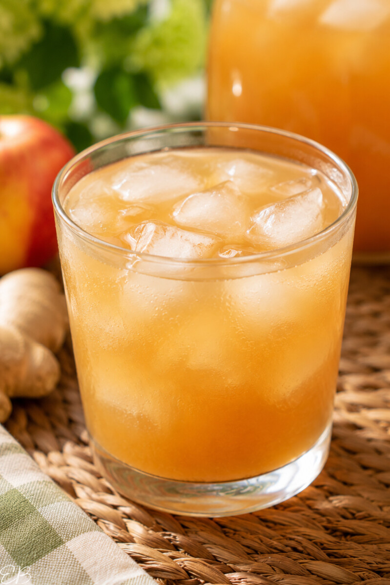 apple ginger iced tea served over ice in clear glass, close up