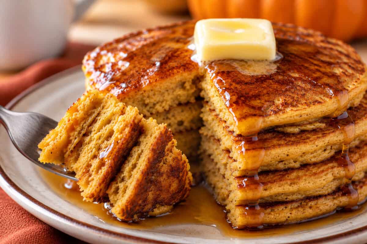 landscape photo of GF paleo pumpkin pancakes being cut into